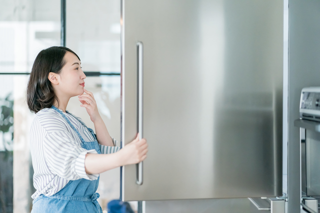 冷蔵庫の中を見る女性